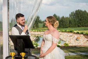 A romantic outdoor wedding scene with a couple posing on a scenic path surrounded by lush greenery.