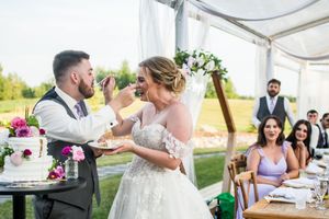 Wedding reception candid moments under white tent with guests celebrating.