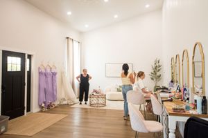 Minimalist white event space with high ceilings and natural light streaming through large windows.