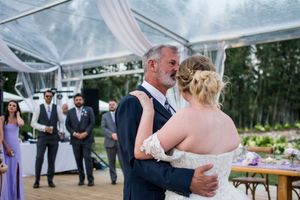 Wedding reception dance sequence under clear tent with romantic lighting.