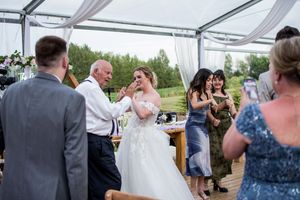Wedding guests enjoying festivities under a clear tent reception space.