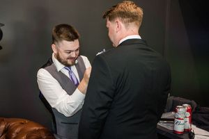Two people in formal attire preparing for an event.