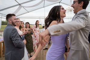 Wedding reception dance floor with guests dancing under a white tent.