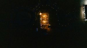 Dark nighttime scene of an outdoor wedding reception venue with ambient lighting.