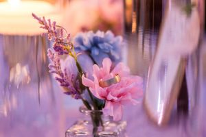 Pink and purple floral arrangements with delicate lighting create a romantic wedding ceremony backdrop.