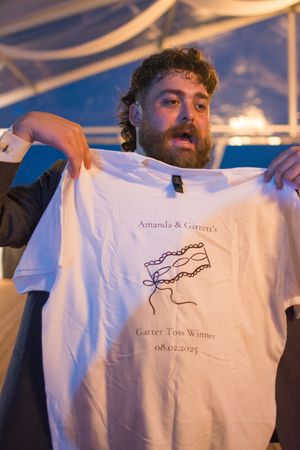Custom wedding t-shirts being displayed at sunset with names and date printed on them.