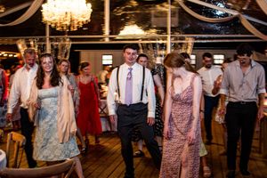 Wedding reception dance floor filled with guests celebrating under warm lighting.