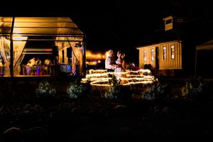 Warmly lit wedding venue buildings glowing at night with romantic ambient lighting.