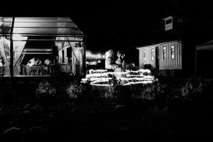 Dramatic black and white nighttime silhouette of wedding venue buildings.