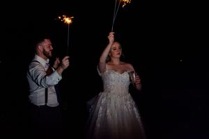 Evening wedding reception celebration with glowing lights in the background.