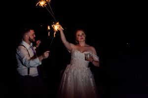 Wedding guests celebrating with sparklers in the dark creating a festive nighttime atmosphere.