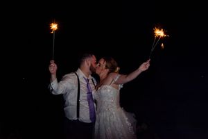 Nighttime wedding celebration with sparklers lighting up the darkness.