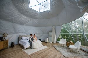 Modern geometric dome tent interior with white fabric panels and natural lighting.