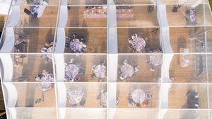 Aerial view of wedding guests seated at reception tables on a wooden deck during an outdoor celebration.