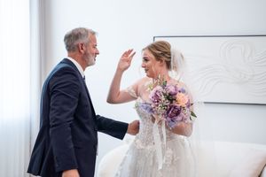 Emotional moment captured during wedding preparations in a bright room.