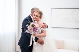 Tender embrace shared during wedding day preparations.