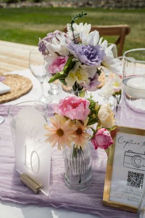 Elegant table settings with purple accents and floral centerpieces at wedding reception.