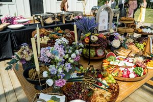 Rustic wedding reception display featuring charcuterie boards and floral arrangements.