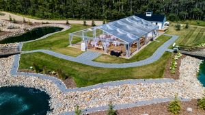 Aerial view of a waterfront venue with multiple outdoor areas and buildings surrounded by greenery.