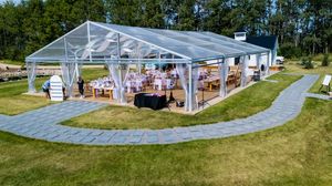Wide aerial view of an outdoor wedding venue with white tents and curved pathways.