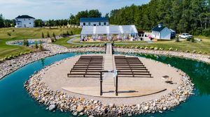 Panoramic view of an outdoor wedding venue with stone walkway and waterfront seating area.