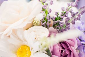 Delicate floral arrangement with purple and pink blooms against a soft pastel background.