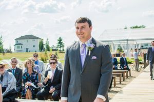 Guests and wedding party gathered outside during sunny outdoor ceremony.