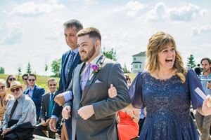 Wedding guests mingling and socializing outdoors on a sunny day.