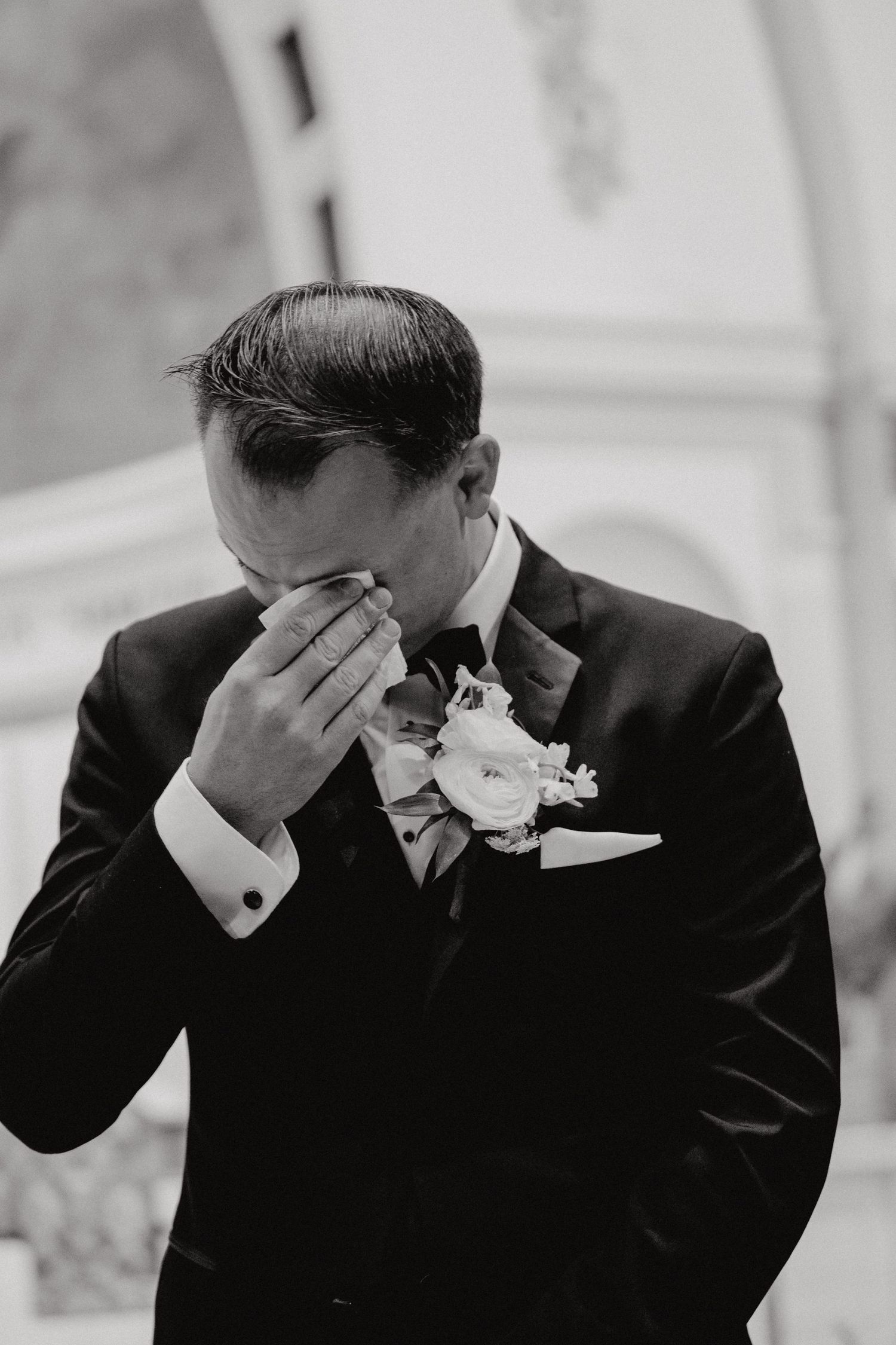 Black and white photo sequence showing a person in a suit wiping tears from their eyes in an emotional moment.