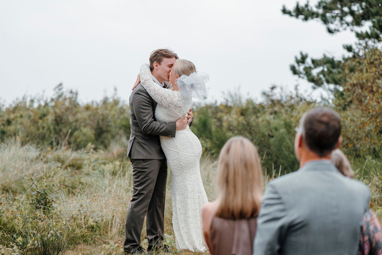 A romantic black and white wedding photo series showing a couple in formal attire sharing intimate moments outdoors.