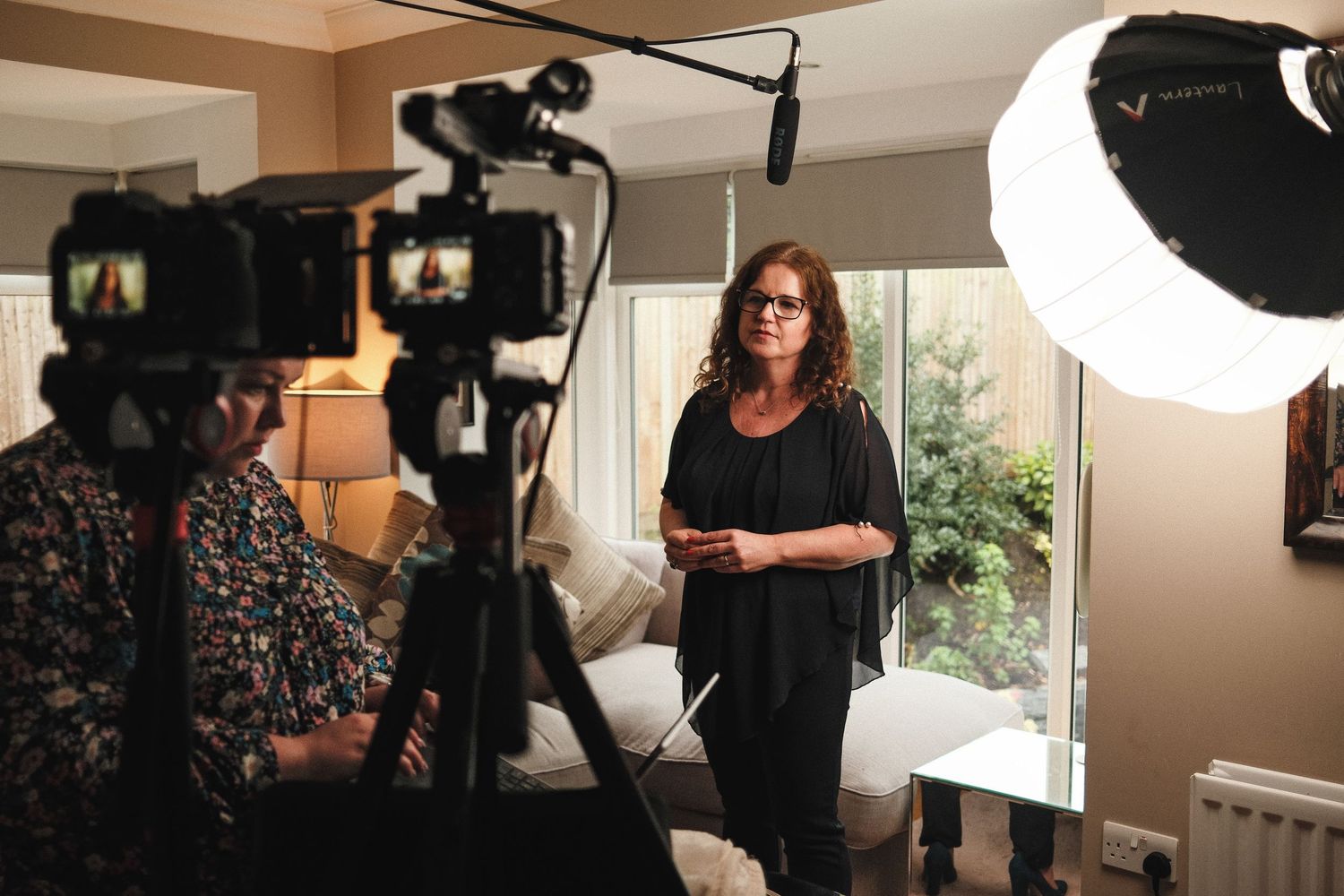Behind-the-scenes photo showing Bass film co production crew with lighting equipment and cameras in an indoor setting.