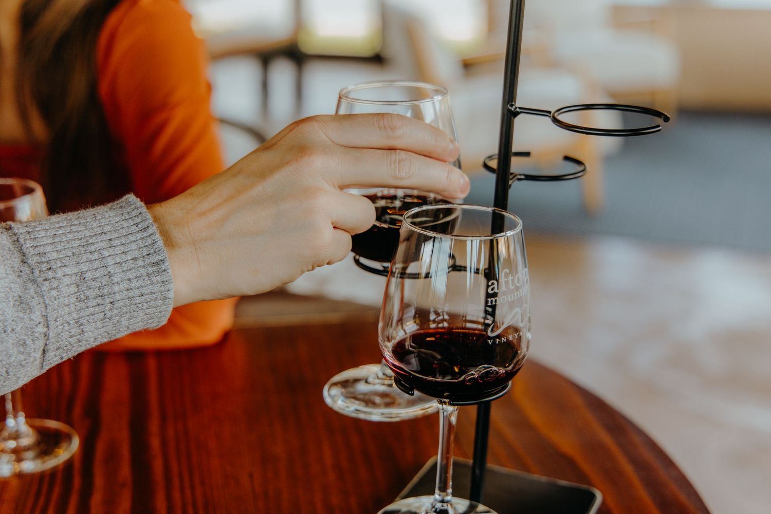 Wine glasses clink together in celebration during a cozy indoor gathering.