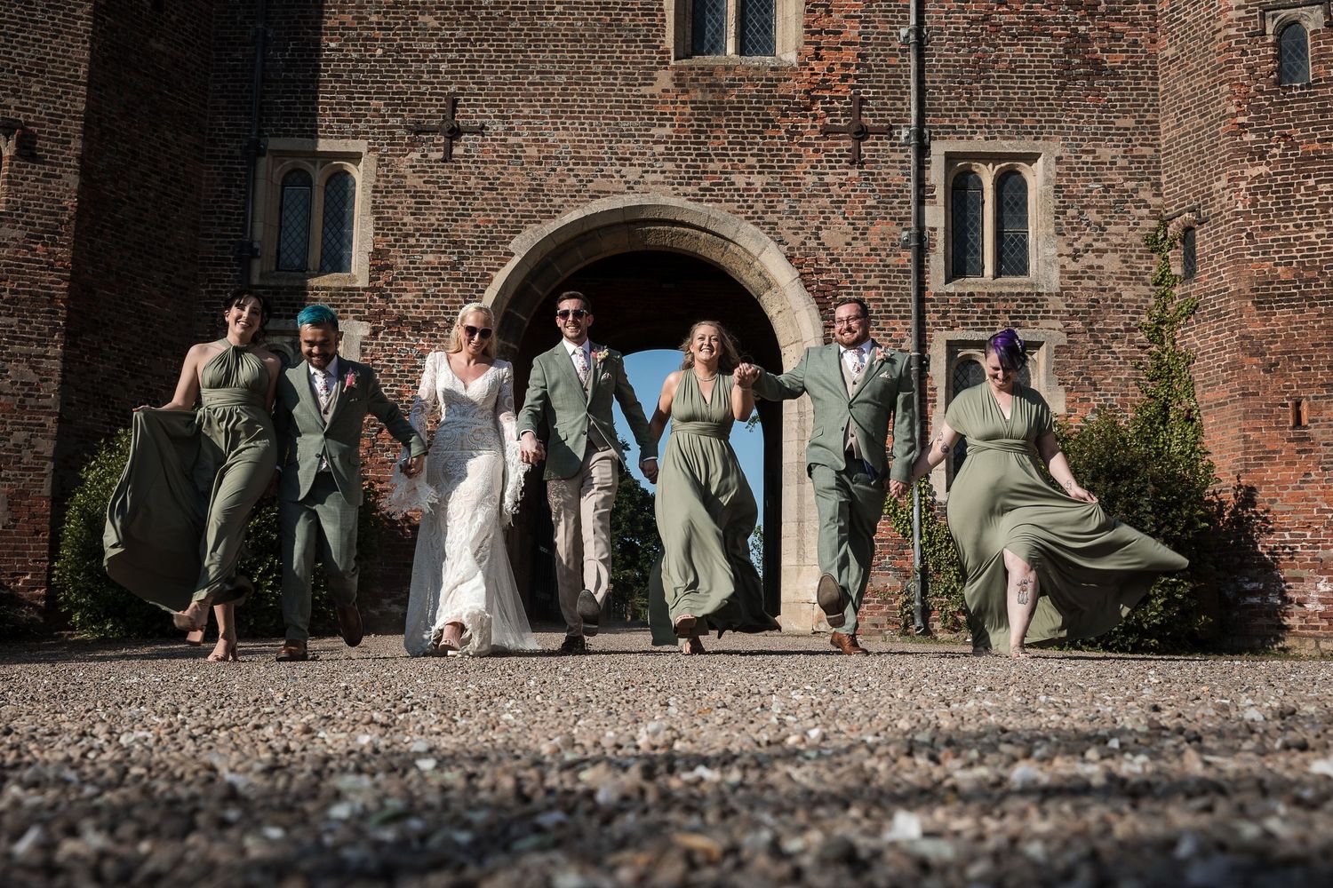 Bridal party laughing together in the grounds of Hodsock Priory