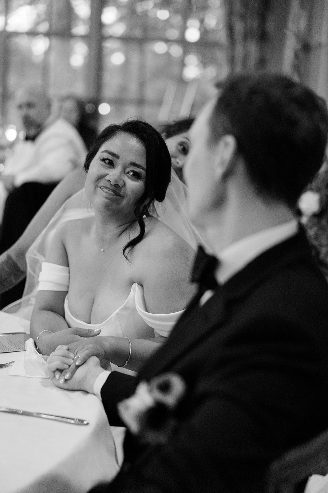 A series of black and white photos showing people seated at a formal dining table in an elegant restaurant setting.