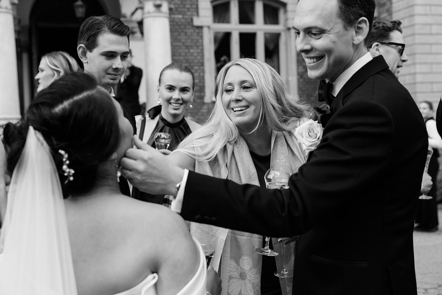 Black and white wedding photo collage showing candid moments of celebration and laughter at a reception.