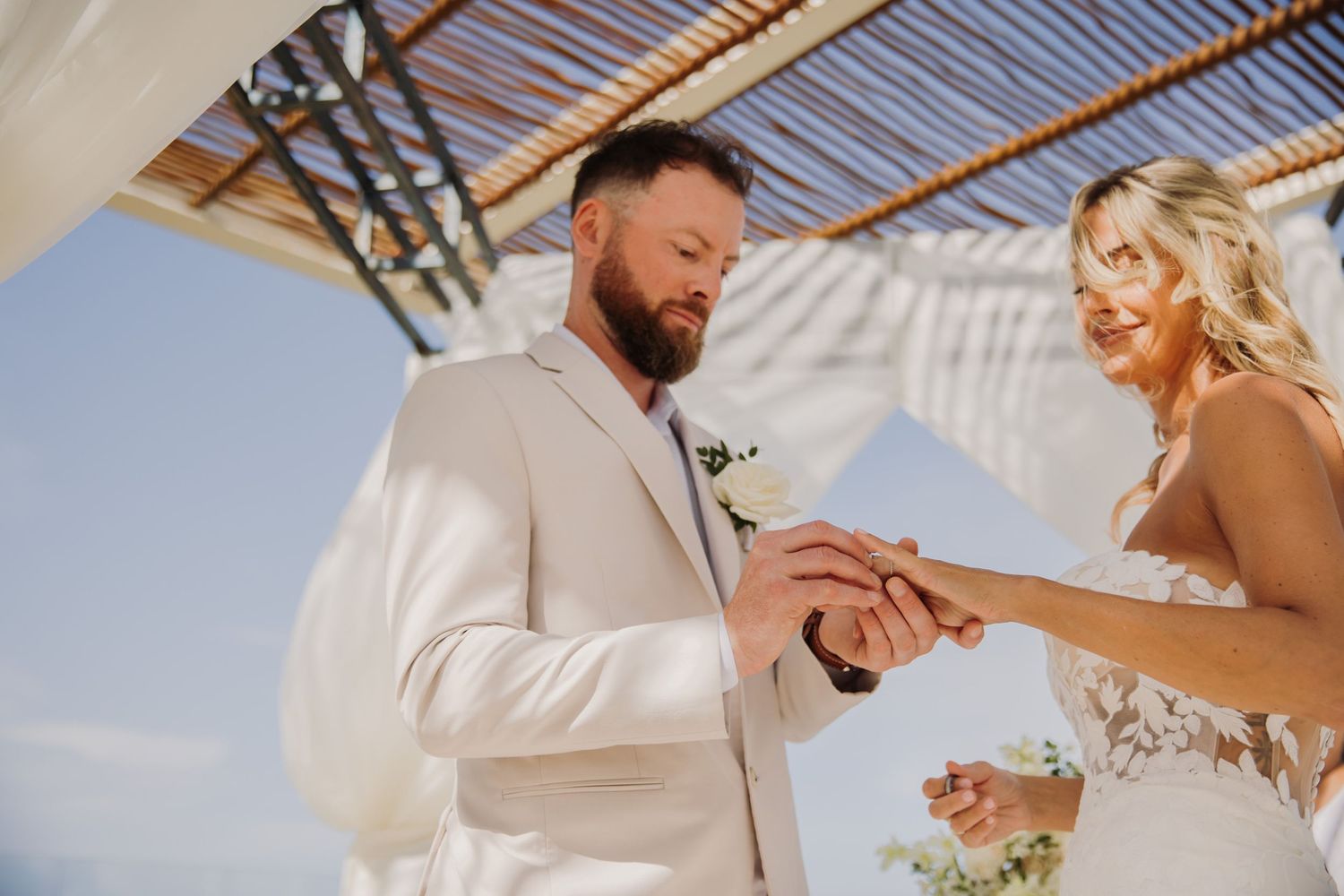 Outdoor wedding ceremony under bamboo pergola with white floral decorations and ocean view. Dreams Sapphire Riviera Maya Wedding Photography