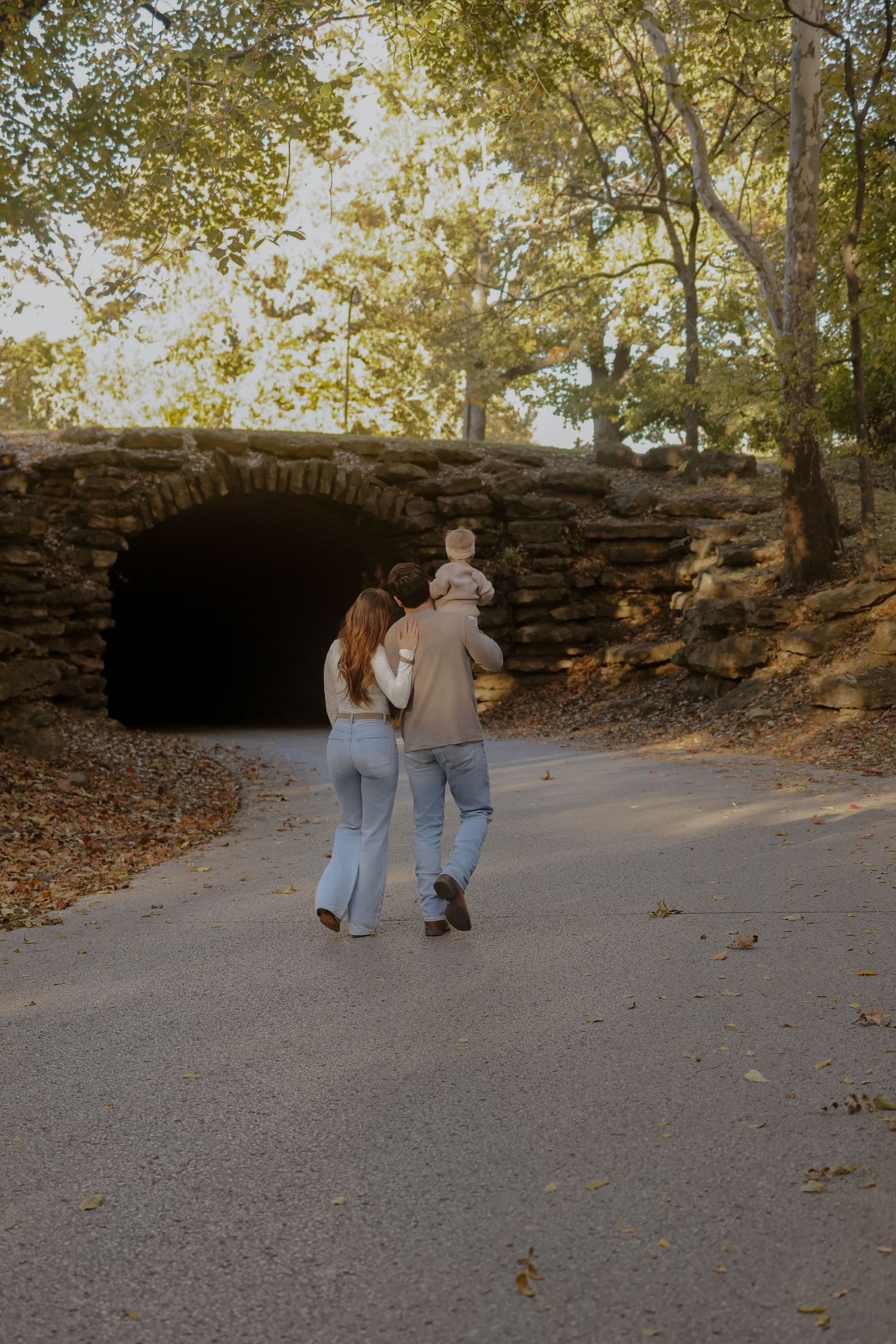 Walking sequence along stone wall path during autumn with fallen leaves.