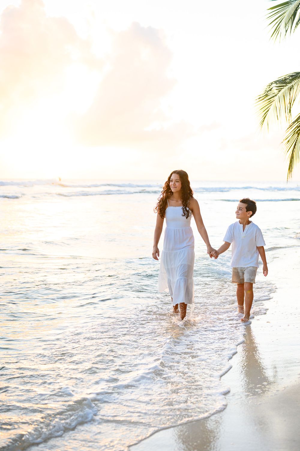 Siblings on the beach in Barbados at golden hour