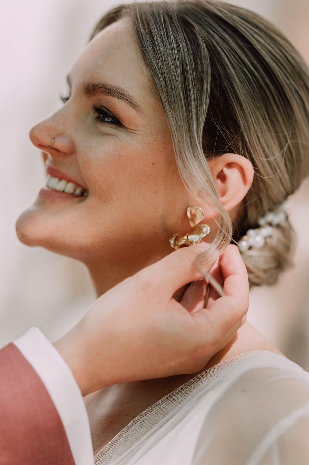 Close-up sequence of putting on elegant bridal earrings during wedding preparations.