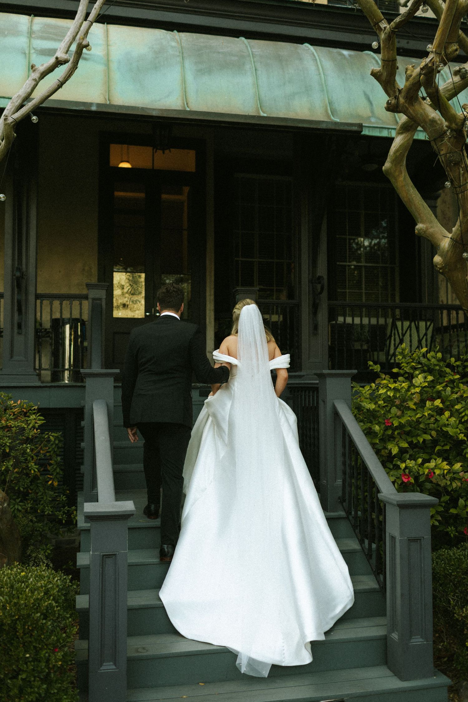 A couple walking up the steps of their wedding venue in Savannah, Georgia after their courtyard wedding ceremony.