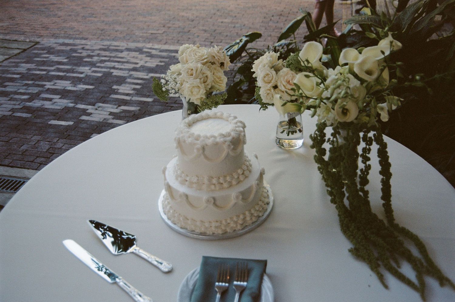 A collection of elegant wedding reception photos showing white tiered cakes, floral centerpieces and table settings.