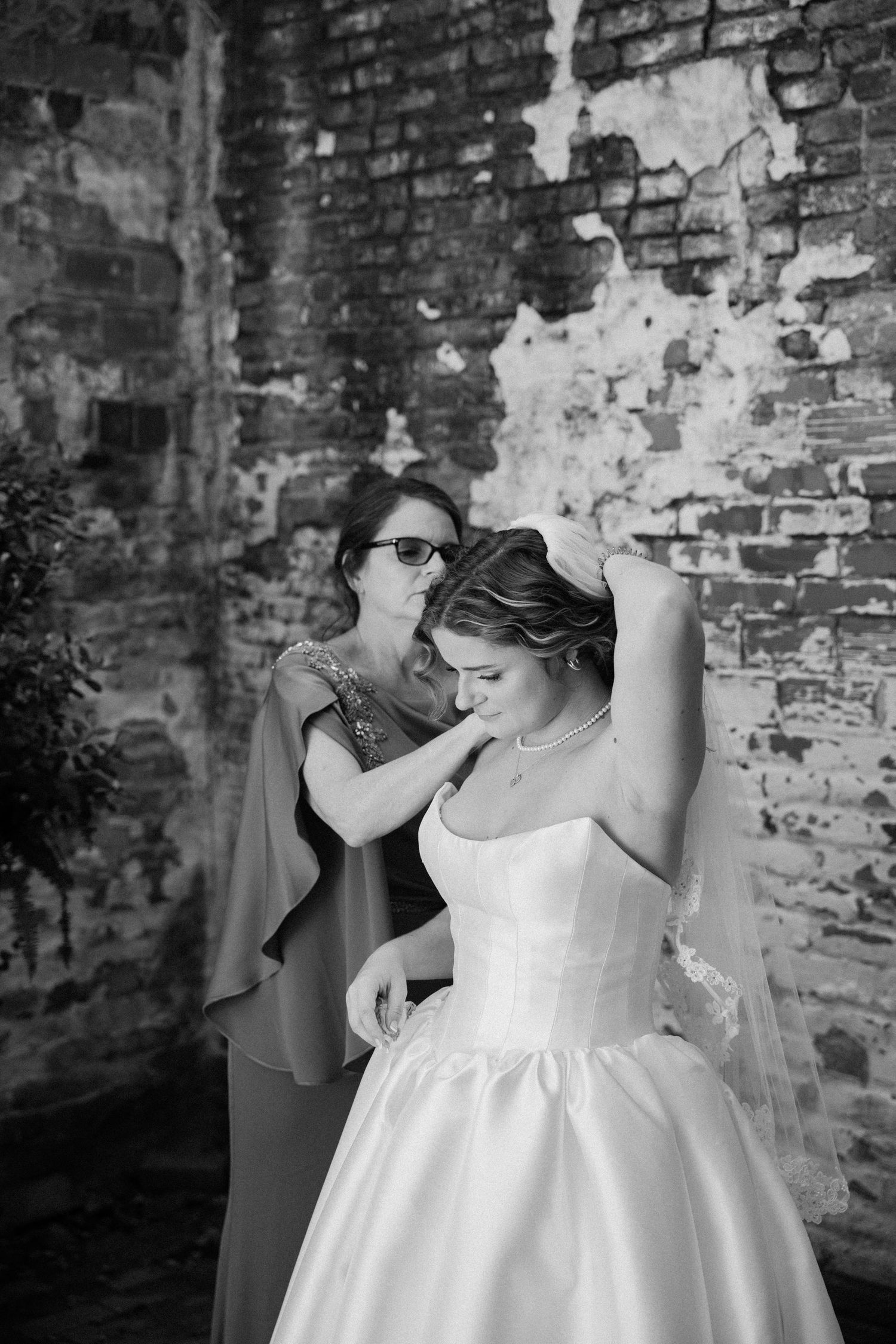 Black and white photo sequence showing a white wedding dress against exposed brick wall in vintage style setting.