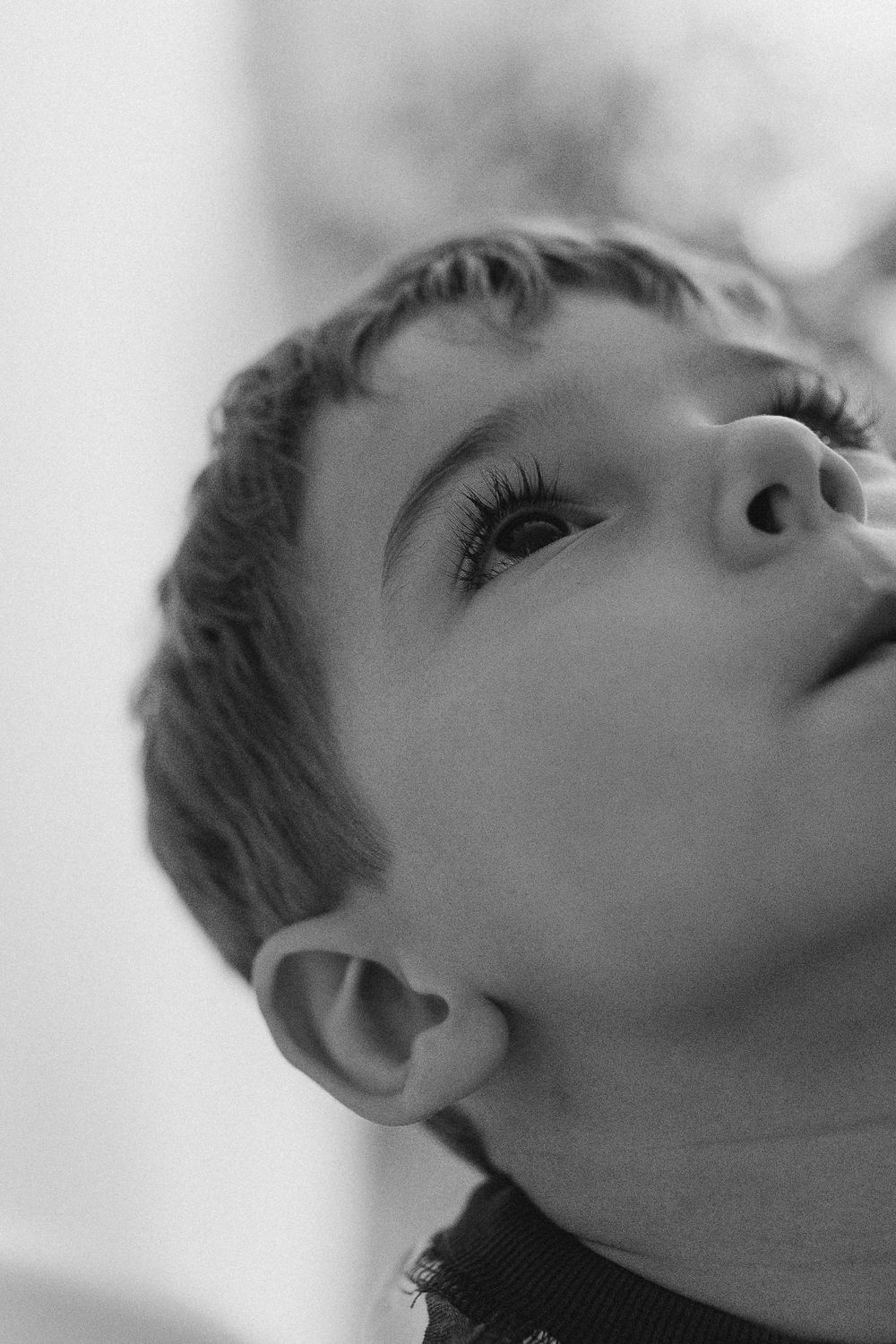 A series of black and white profile portraits showing someone looking upward in a contemplative artistic pose.