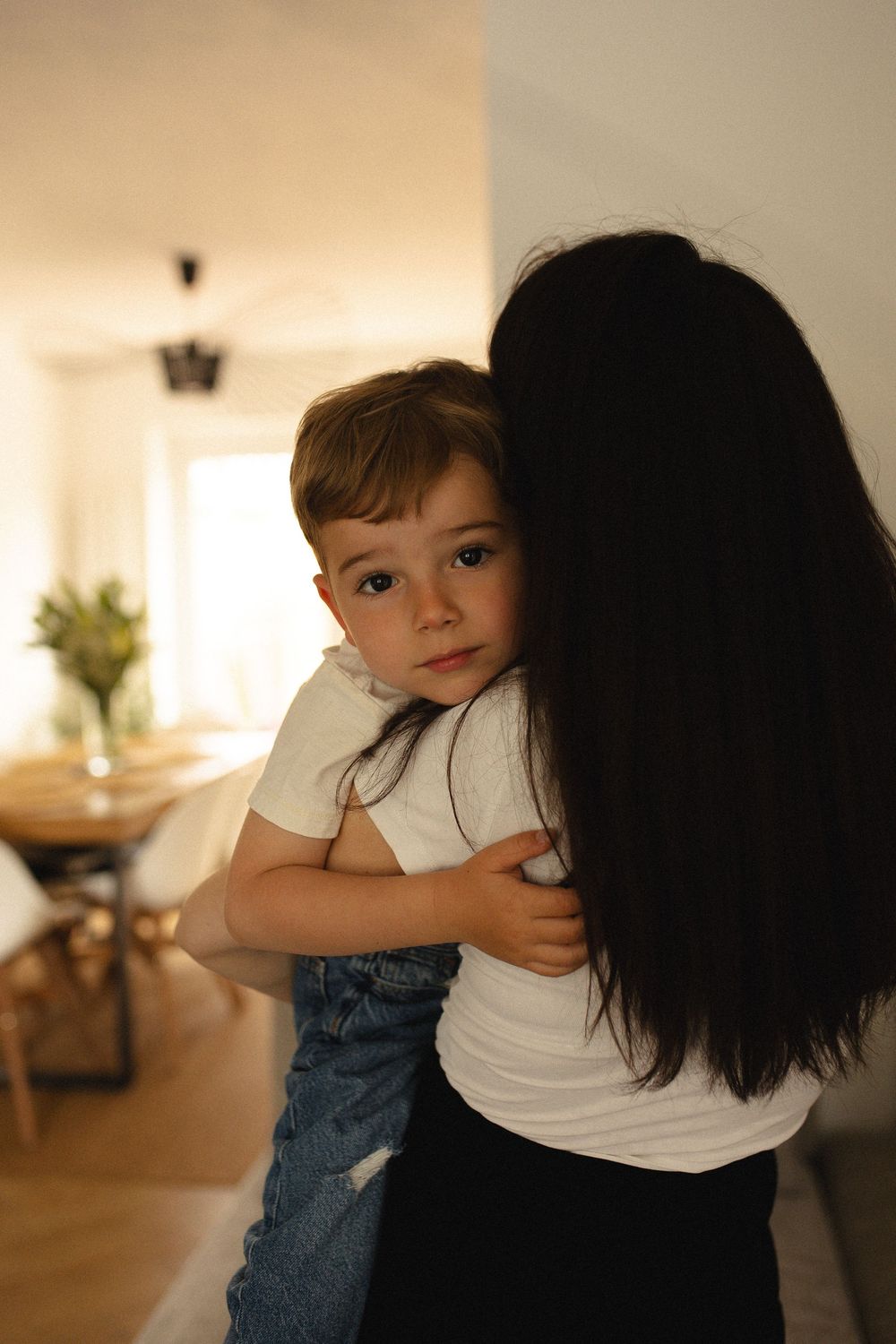 A series of candid moments showing playful interaction and hugging in a bright indoor setting.