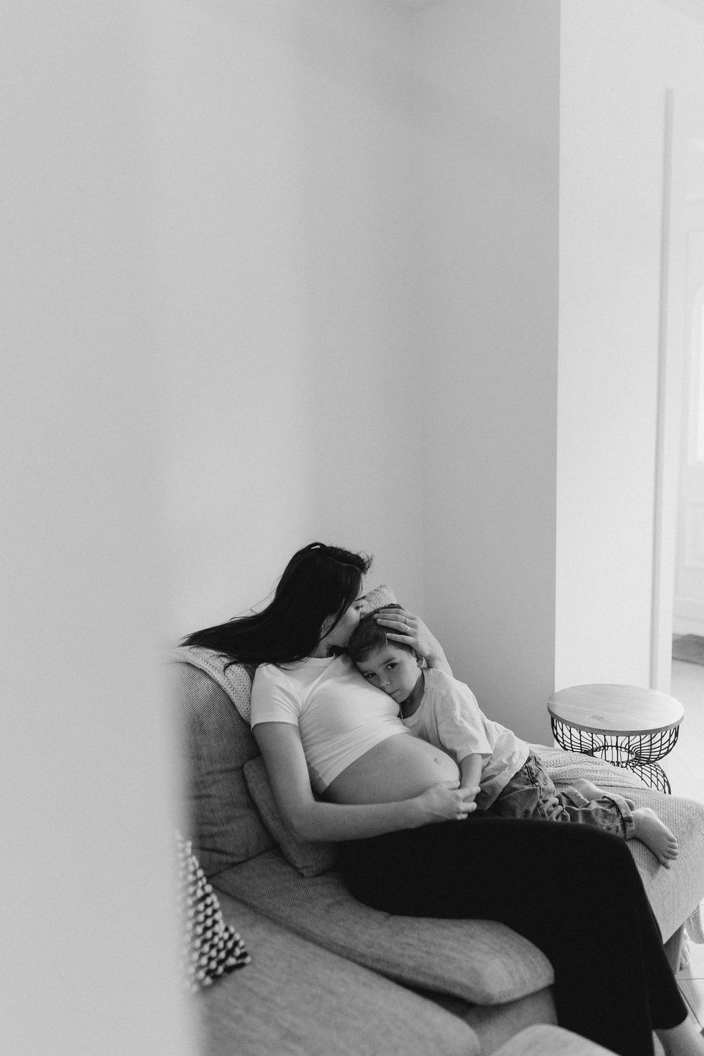 Intimate black and white photos of a couple resting together on a couch.