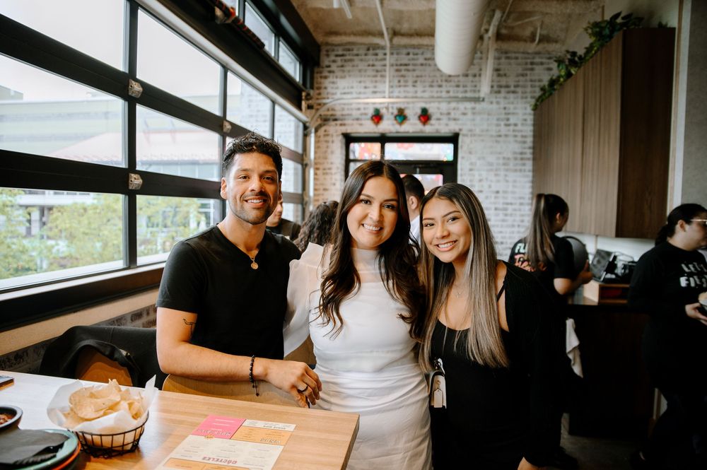 Friends enjoying a casual gathering at a modern restaurant with exposed brick walls and natural lighting.