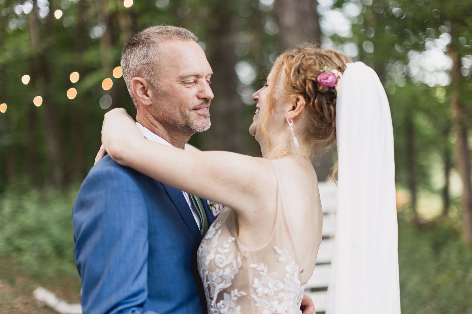 A couple shares an intimate moment under string lights at an outdoor wedding reception. Superior Wisconsin Duluth Minnesota Wedding Photogra