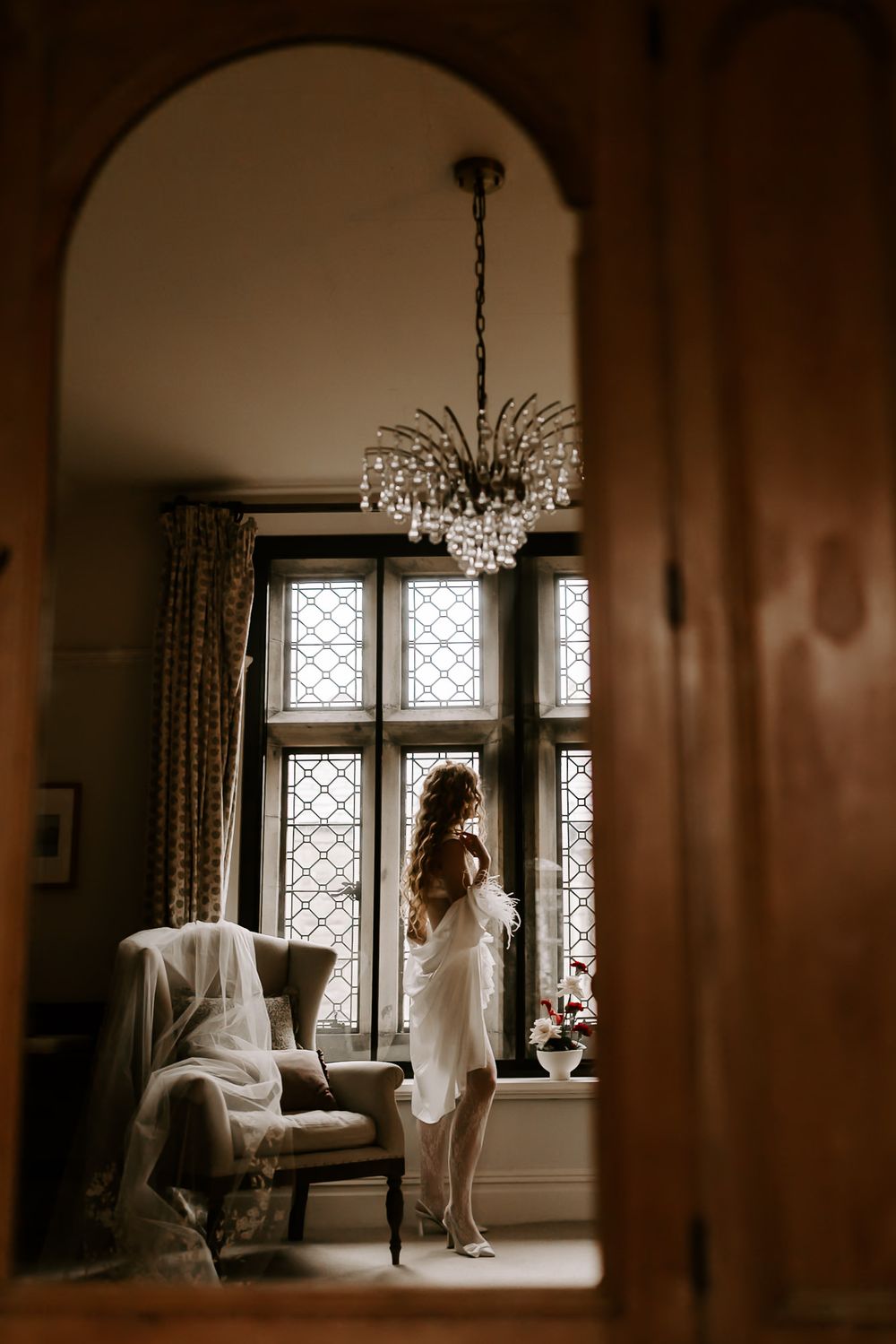 A series of sepia-toned photos showing a bride in a wedding dress looking out ornate windows in an elegant room.