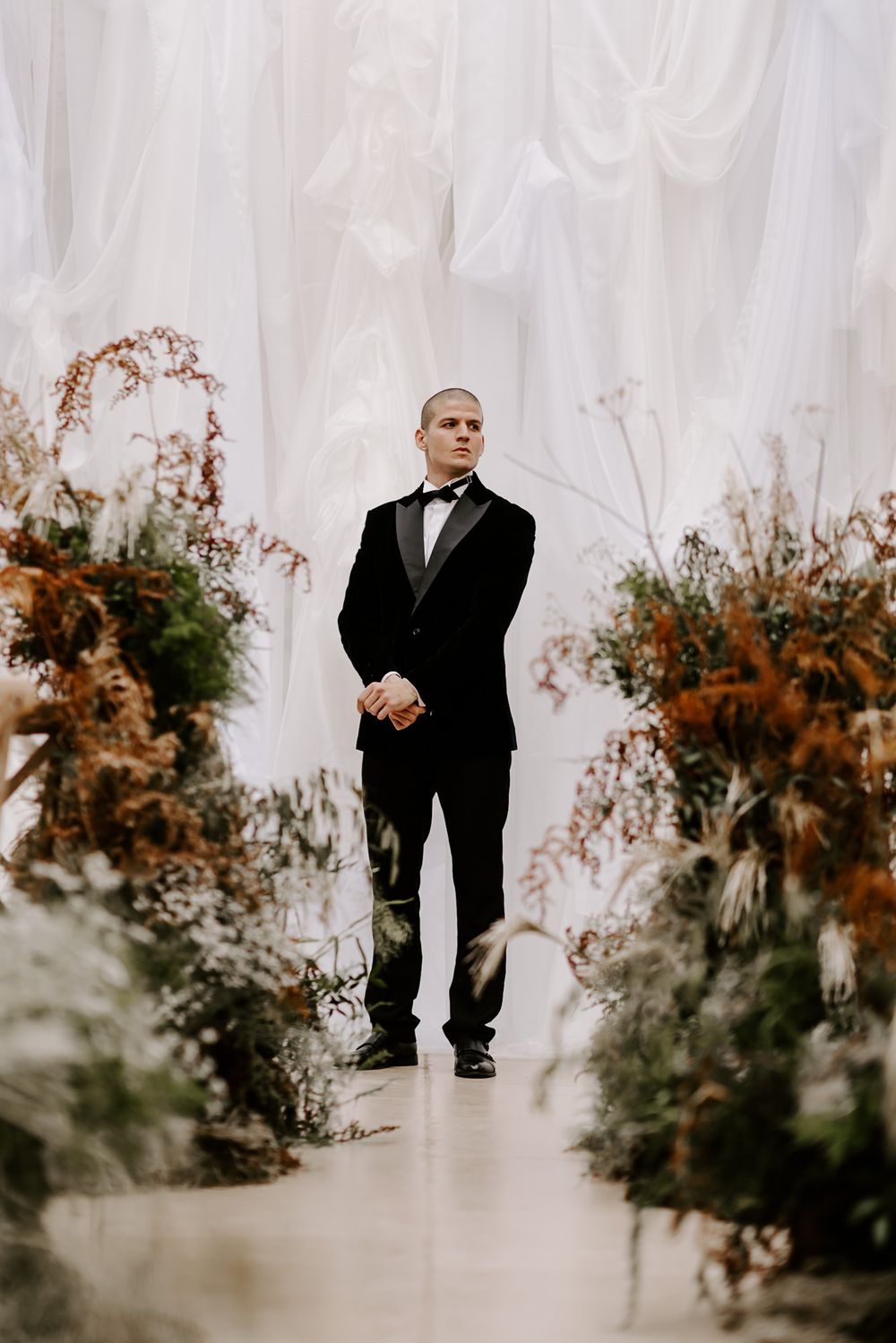 A series of four minimalist wedding ceremony photos showing a person in a black suit standing against a white backdrop.