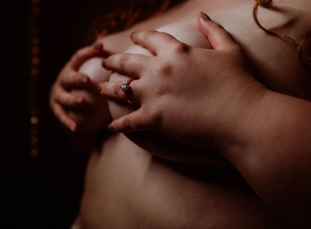 Minneapolis boudoir photography with engagement ring boudoir photos with moody lighting.